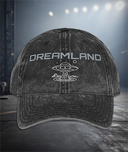 Black vintage-wash "Dreamland" dad hat by AeroSpaceNews with UFO saucer embroidery, featuring a relaxed unstructured fit and antique brass buckle.